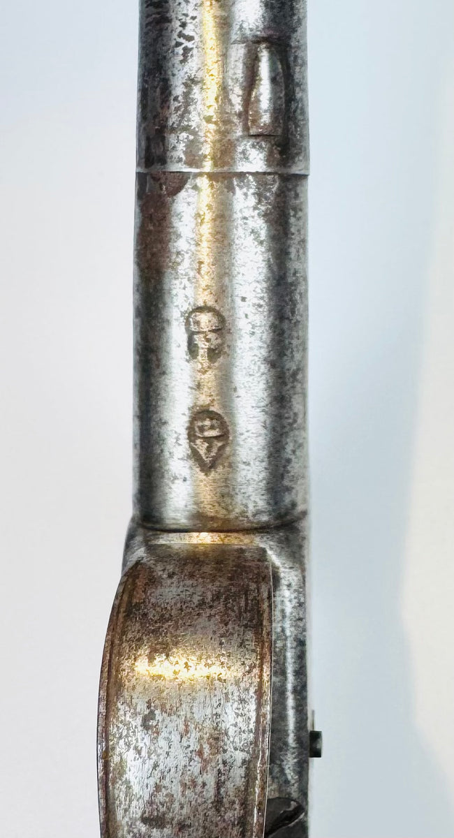Antique percussion pistol displaying aged steel patina and oxidation