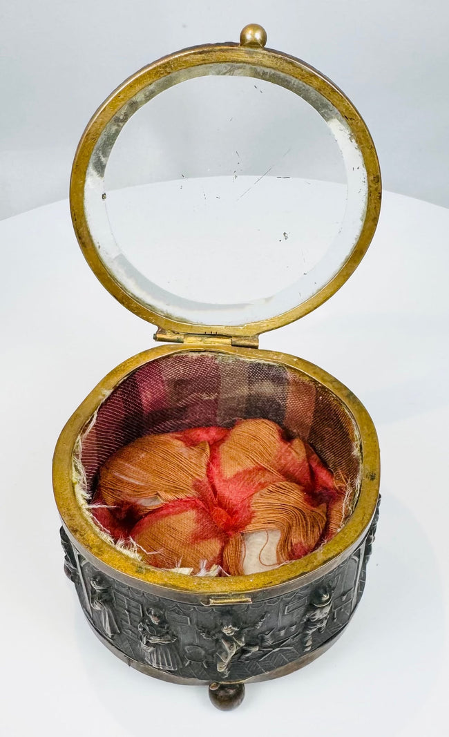 Antique circular jewelry box featuring a thick beveled glass lid