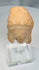 Greek archaeological terracotta fragment on a clear display stand