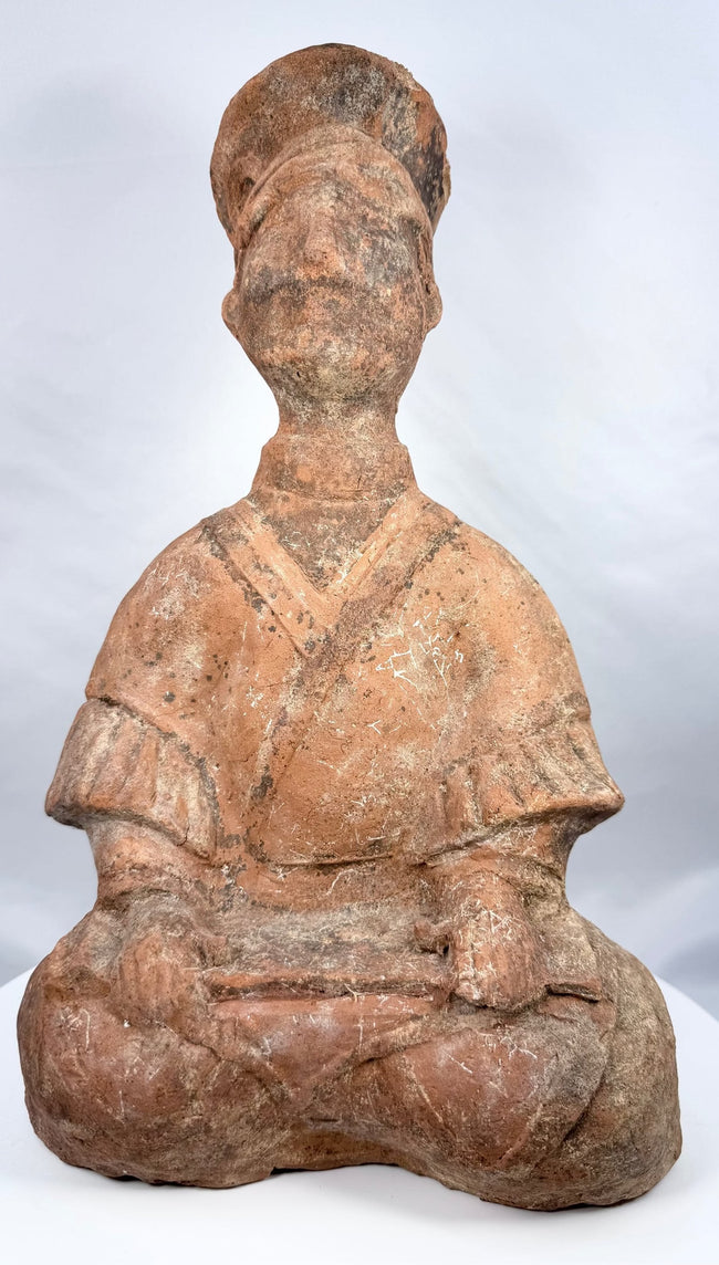 Han Dynasty terracotta musician with tall headdress and crossed legs
