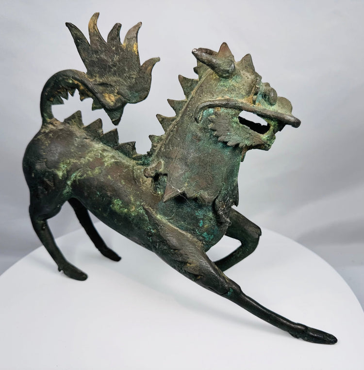 Side profile of a Chinese bronze qilin with an arched tail