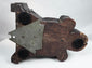 Dark-stained wooden corbel with reddish-brown areas of wear