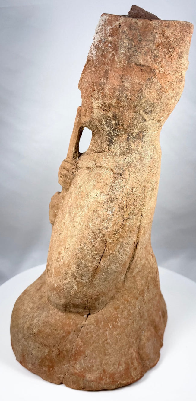 Terracotta musician holding a flute-like instrument with both hands