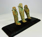 Three ancient Egyptian faience ushabti figures viewed from a diagonal angle on a black wooden display base.