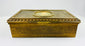 Antique gold decorative box showing engraved floral patterns along the side on a white background.