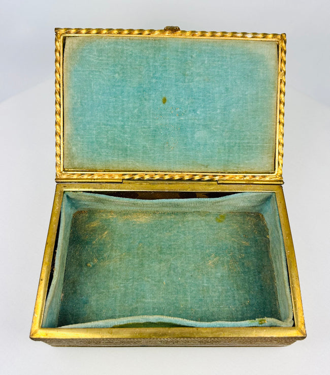 Close-up of the portrait miniature on the lid of an antique gold jewelry box.