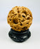 Late Qing carved multi-layer puzzle sphere with dragon designs displayed on a black stand against a white background.