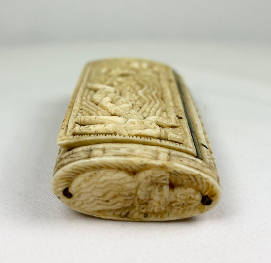 End view of a Napoleonic POW carved bone snuff box displaying tight woven and braided carving patterns on a white background.