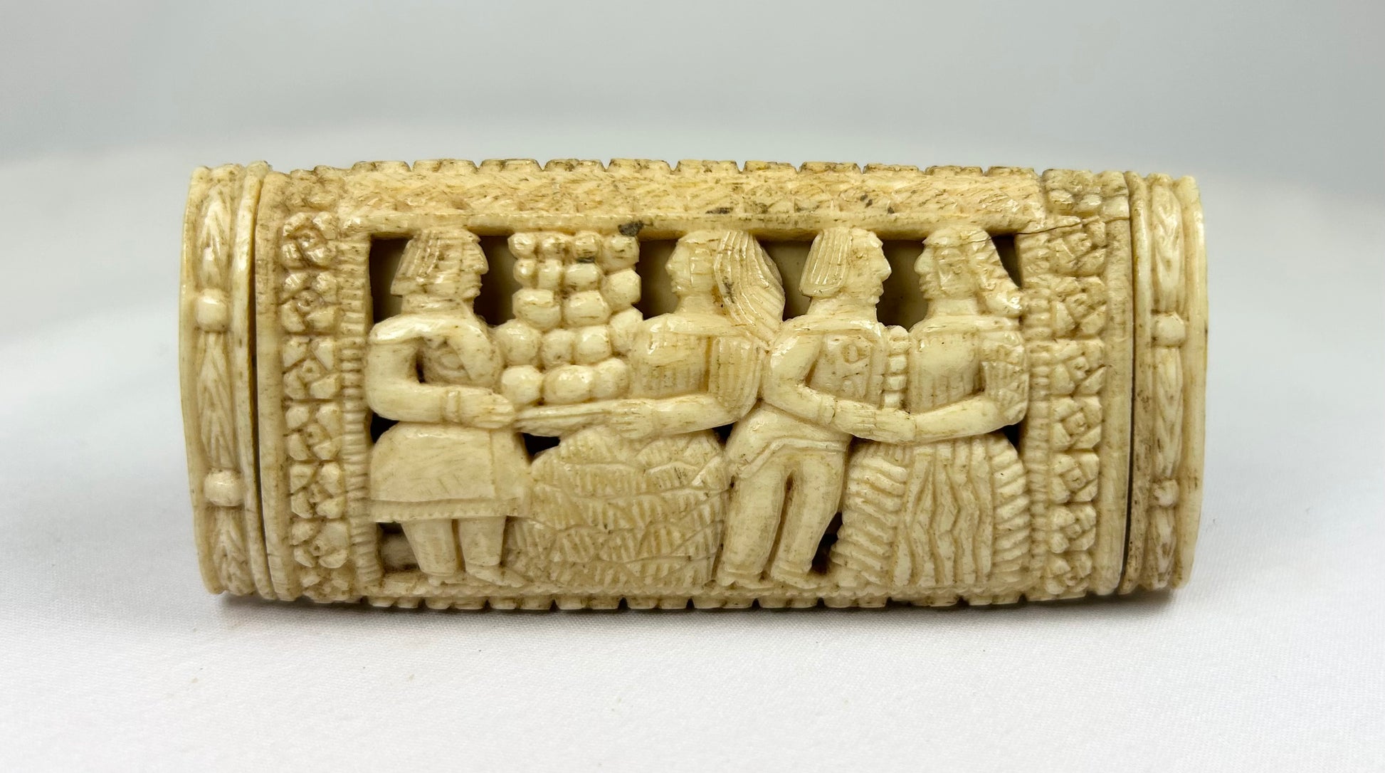 Napoleonic POW carved bone snuff box reverse panel displaying multiple standing figures in relief with lattice and floral borders.