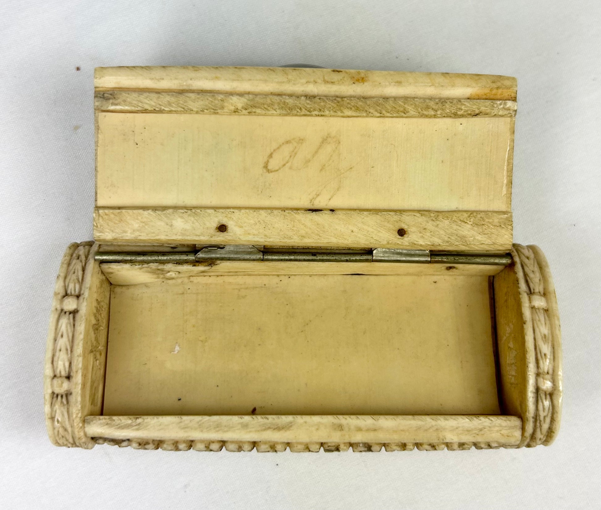 Interior view of an open Napoleonic POW carved bone snuff box showing the original compartment and hand-carved lid on a white background.