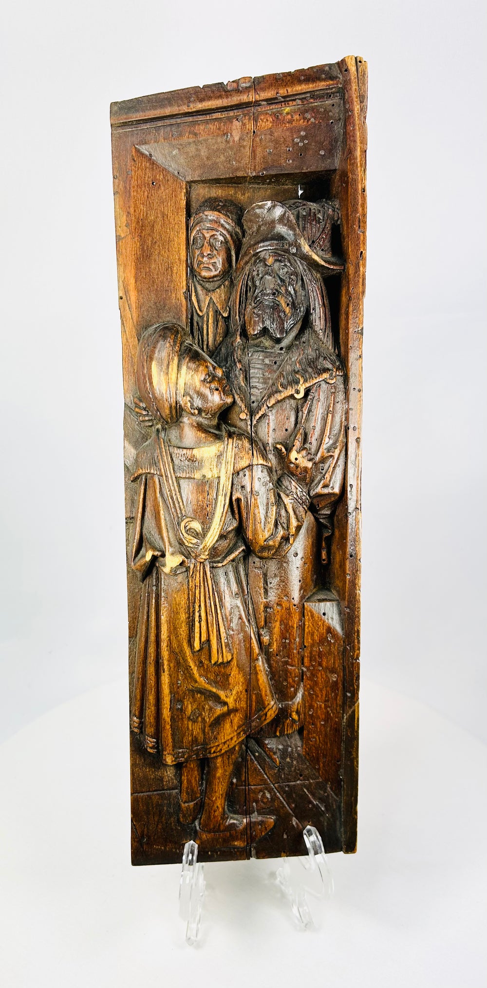 Detailed close-up of Gothic-era carved oak figures with folded drapery and textured patina.