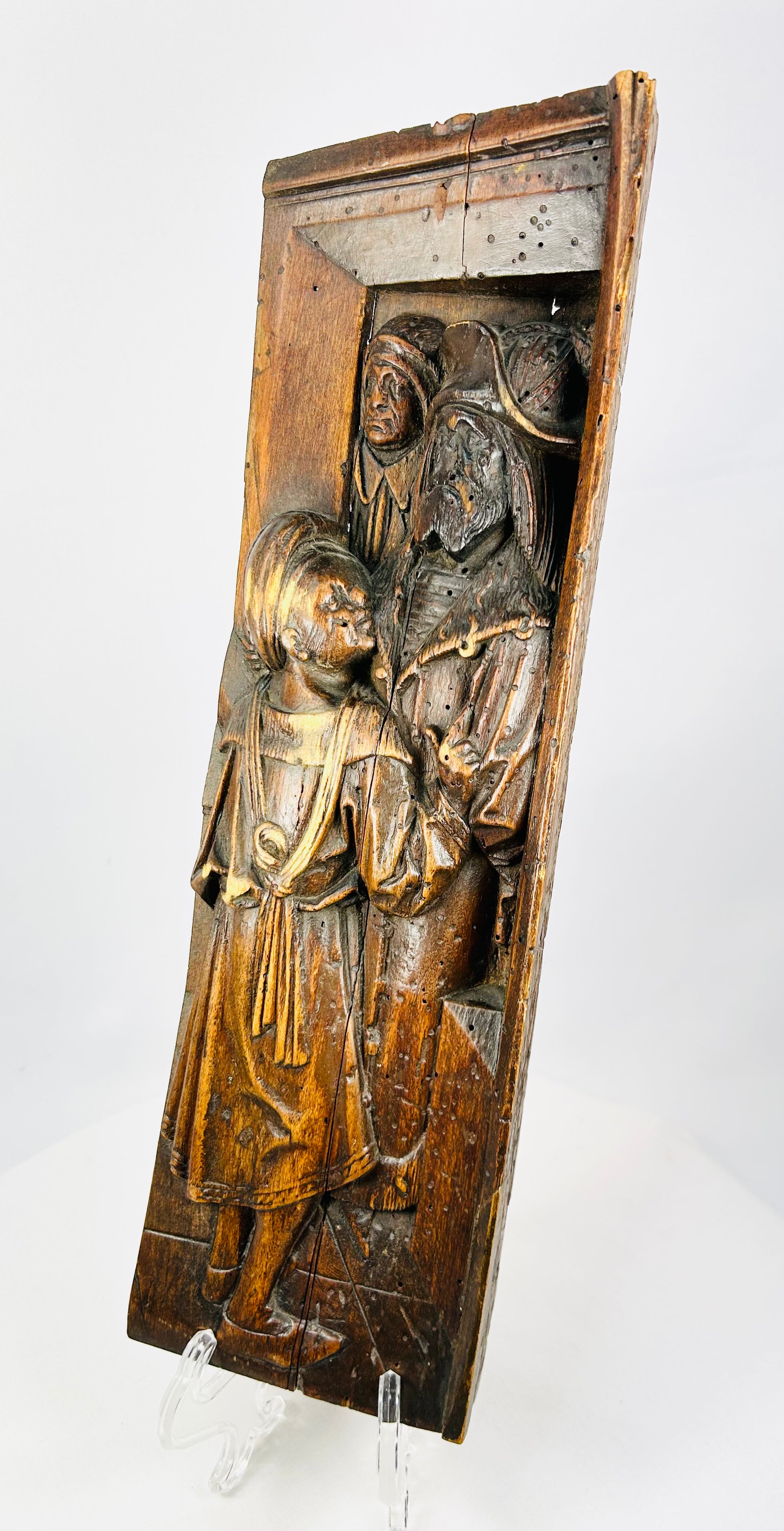 Side angle of 16th-century carved oak relief showing depth of undercutting and sculptural carving.