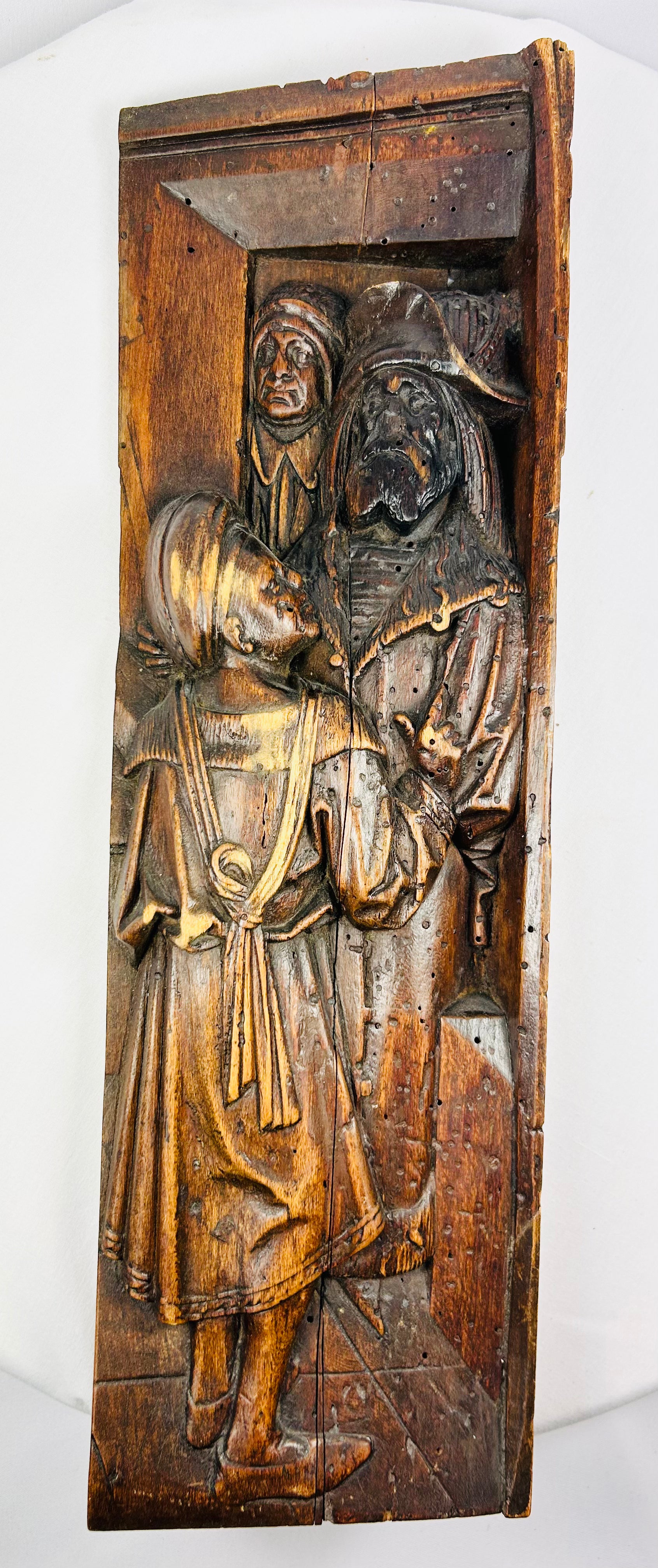 High-relief Renaissance-transition carving on solid oak, featuring two medieval-style figures.