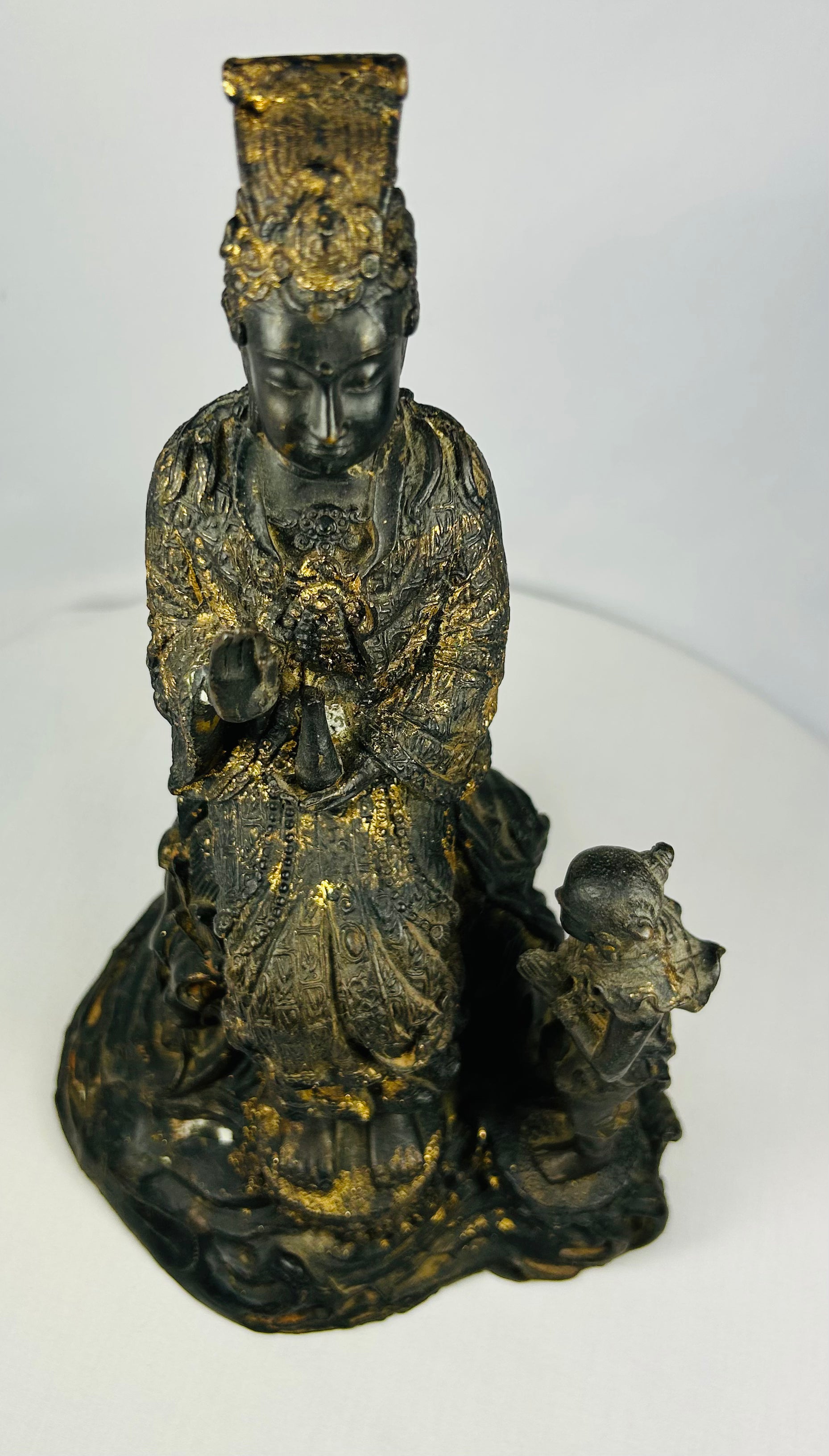 Close-up of Guanyin’s face on Thai bronze statue, showing serene expression and remnants of original gilding.