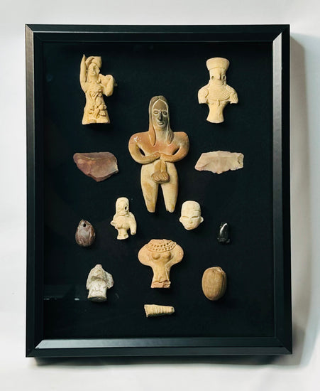 Ancient terracotta and stone artifacts arranged in a curated Pre-Columbian study set.