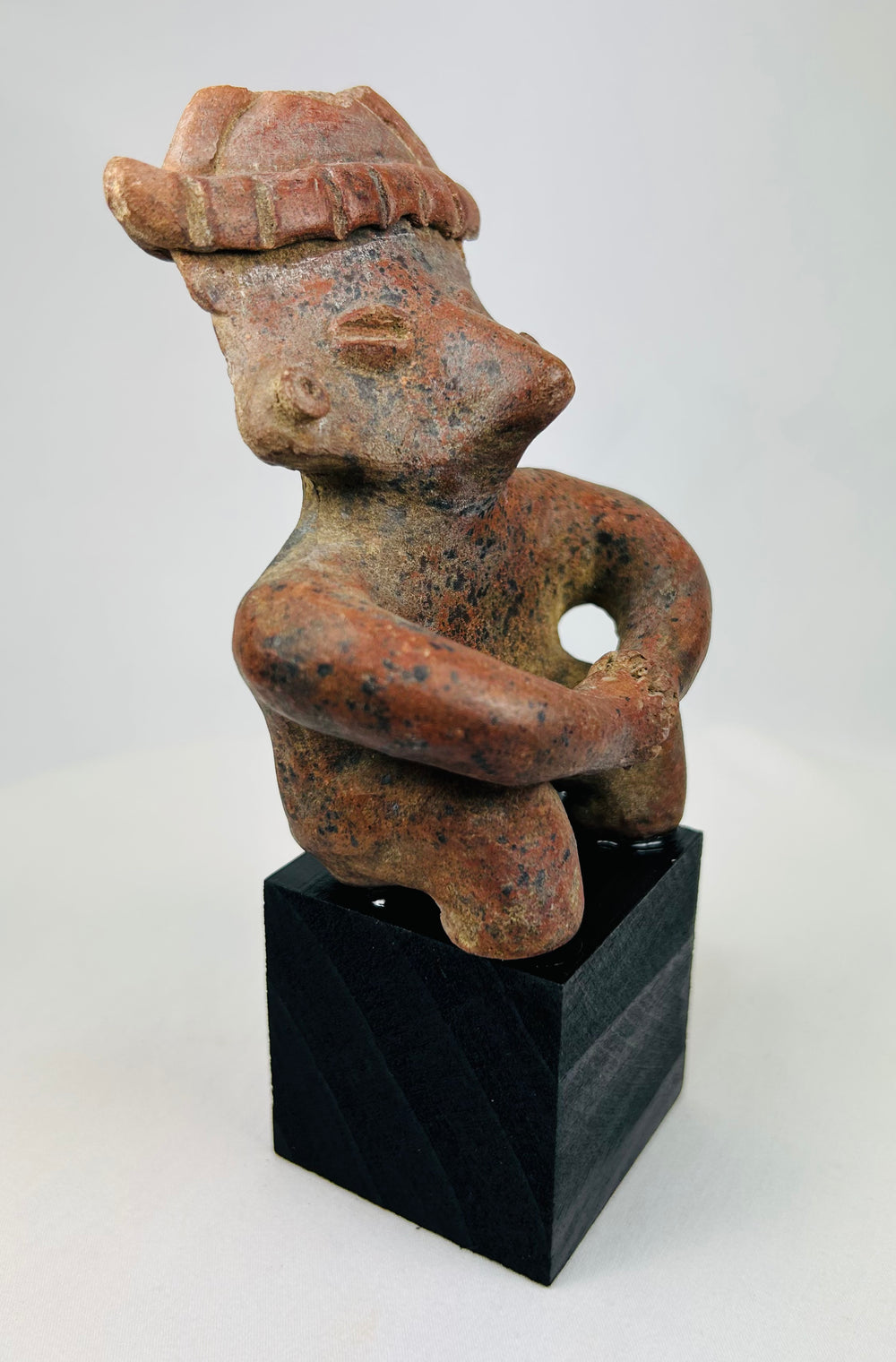 Side view of Pre-Columbian terracotta figure showing profile and headdress.