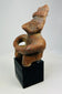 Oblique view of Nayarit seated terracotta sculpture with mineral deposits visible.