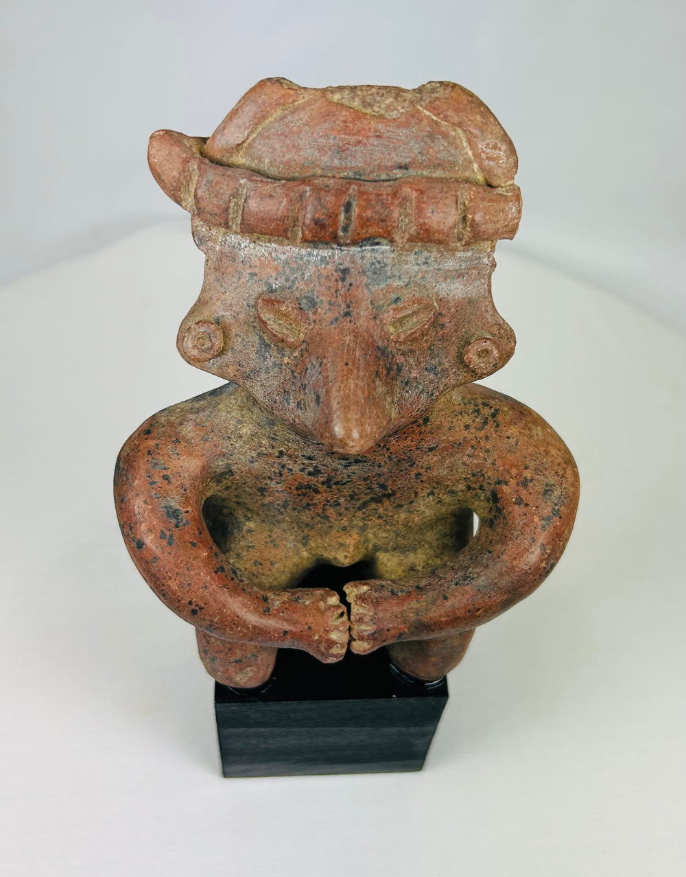 Close-up of terracotta headdress and facial detailing on Nayarit seated figure.