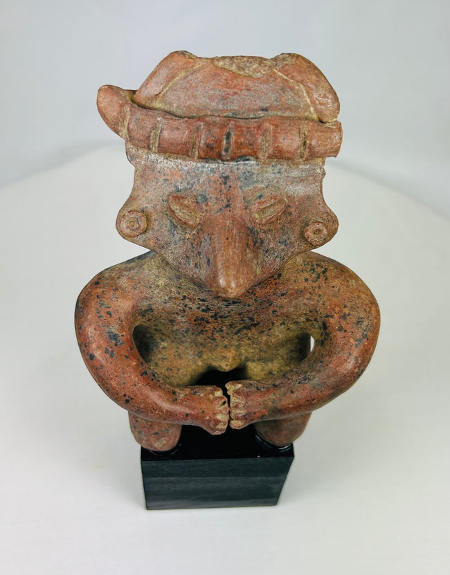Close-up of terracotta headdress and facial detailing on Nayarit seated figure.