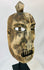 Side profile of a carved wooden ritual mask showing deep patina and sculpted facial contours.