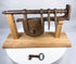 Hand-forged wrought-iron door lock assembly displayed on a custom wooden stand