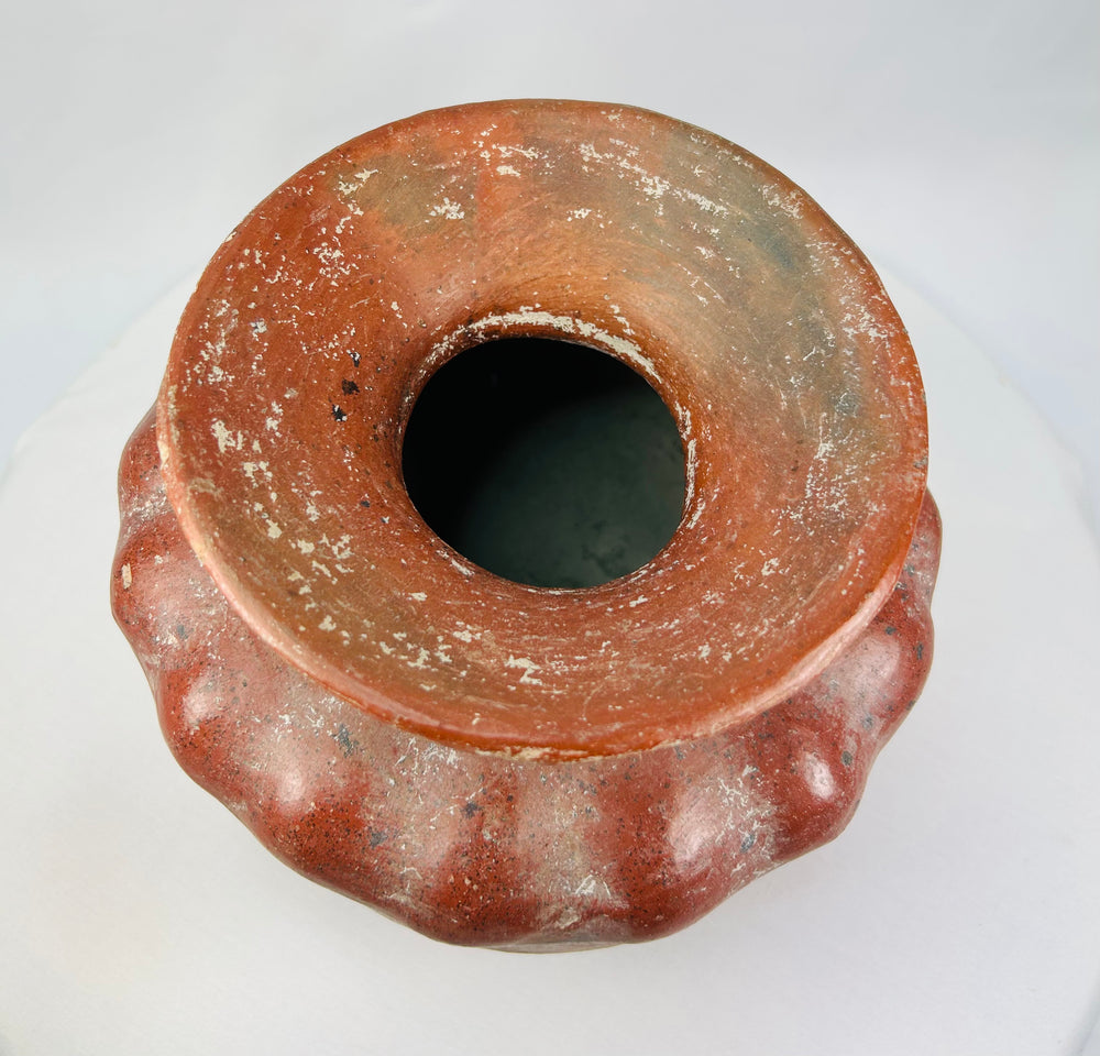Top view of an ancient Pre-Columbian ceramic vessel showing the wide flared rim and mineralized surface.