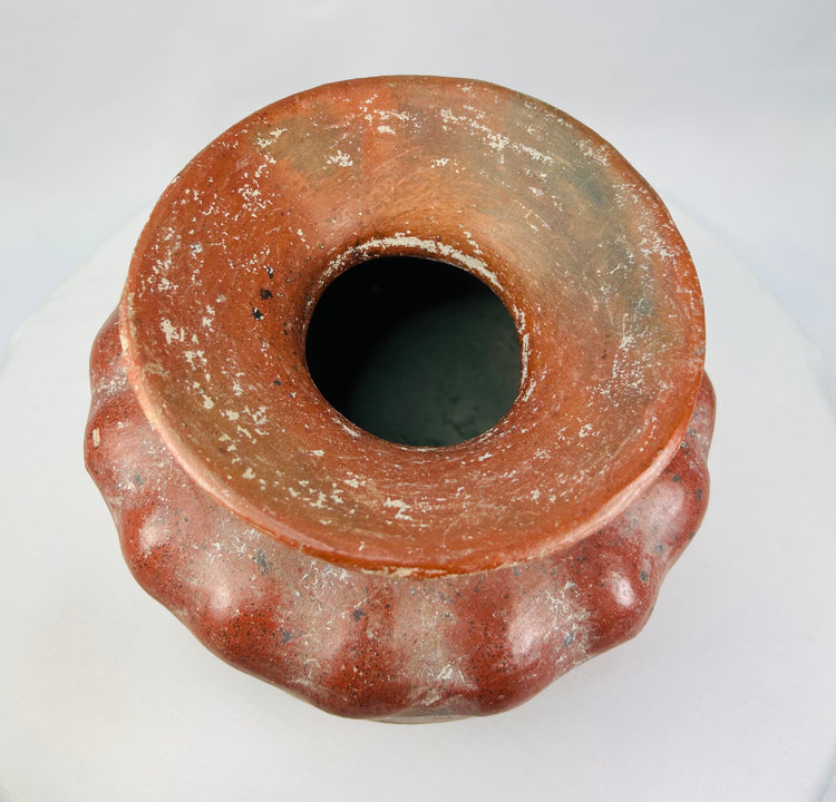 Top view of an ancient Pre-Columbian ceramic vessel showing the wide flared rim and mineralized surface.