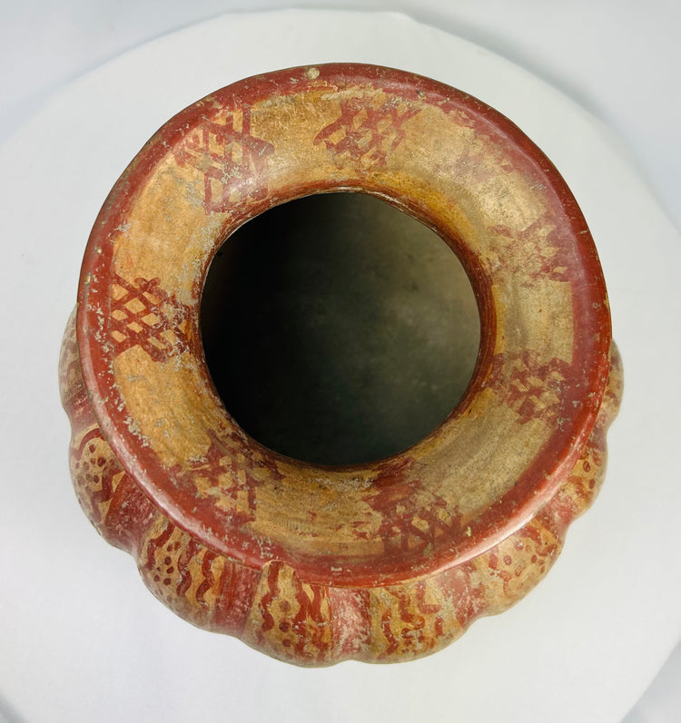 Top view of a Moche-style ceramic vessel showing circular opening and geometric rim motifs.