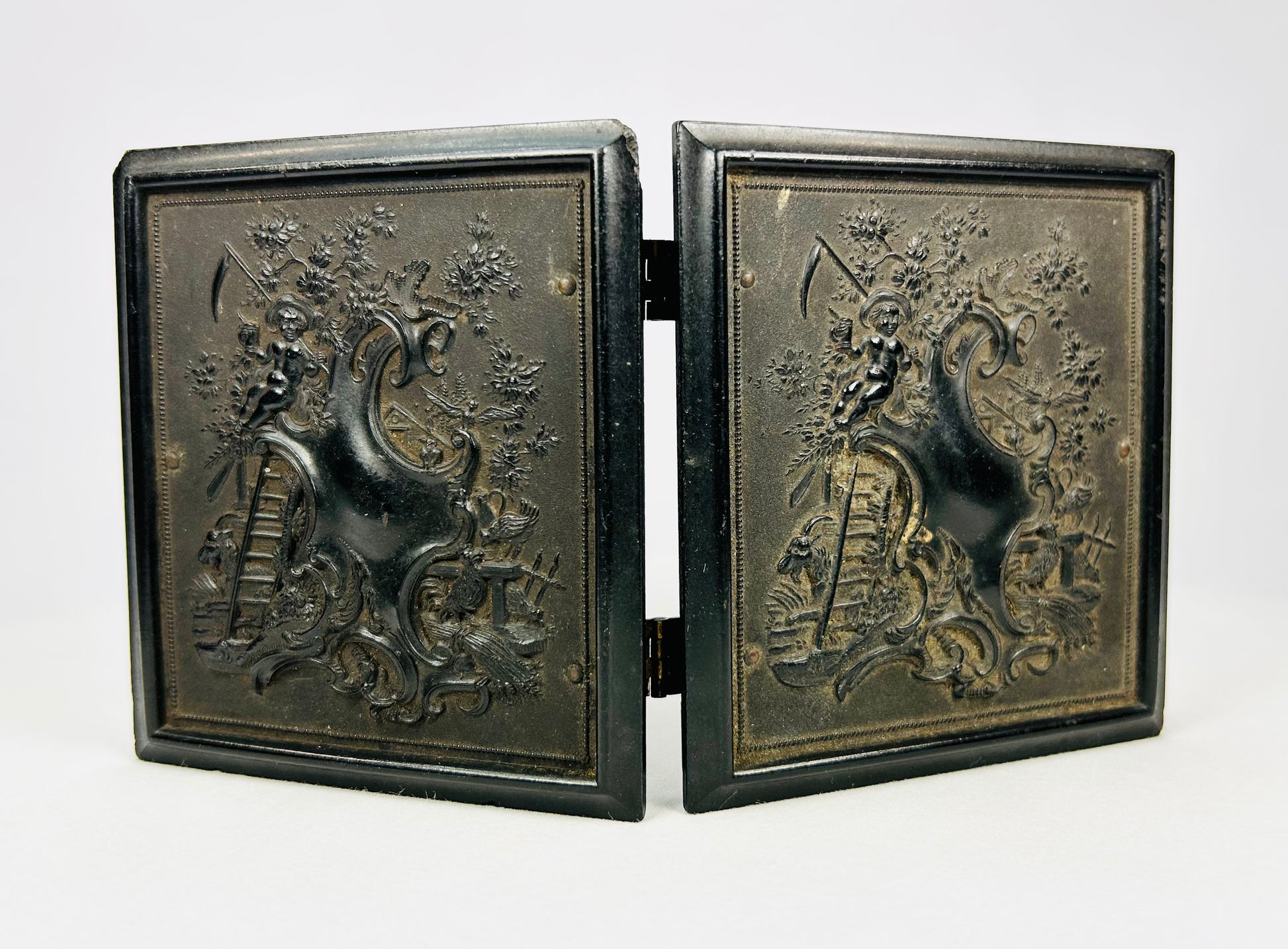 Antique 19th-century photograph case showing ornate raised exterior artwork