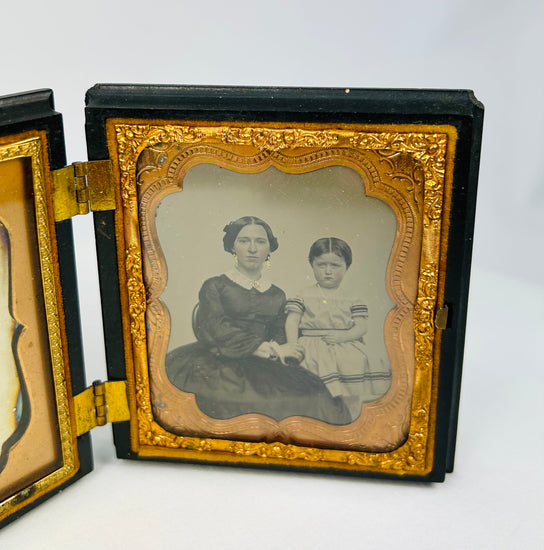 Dual-portrait daguerreotype featuring a woman and child inside an ornate case