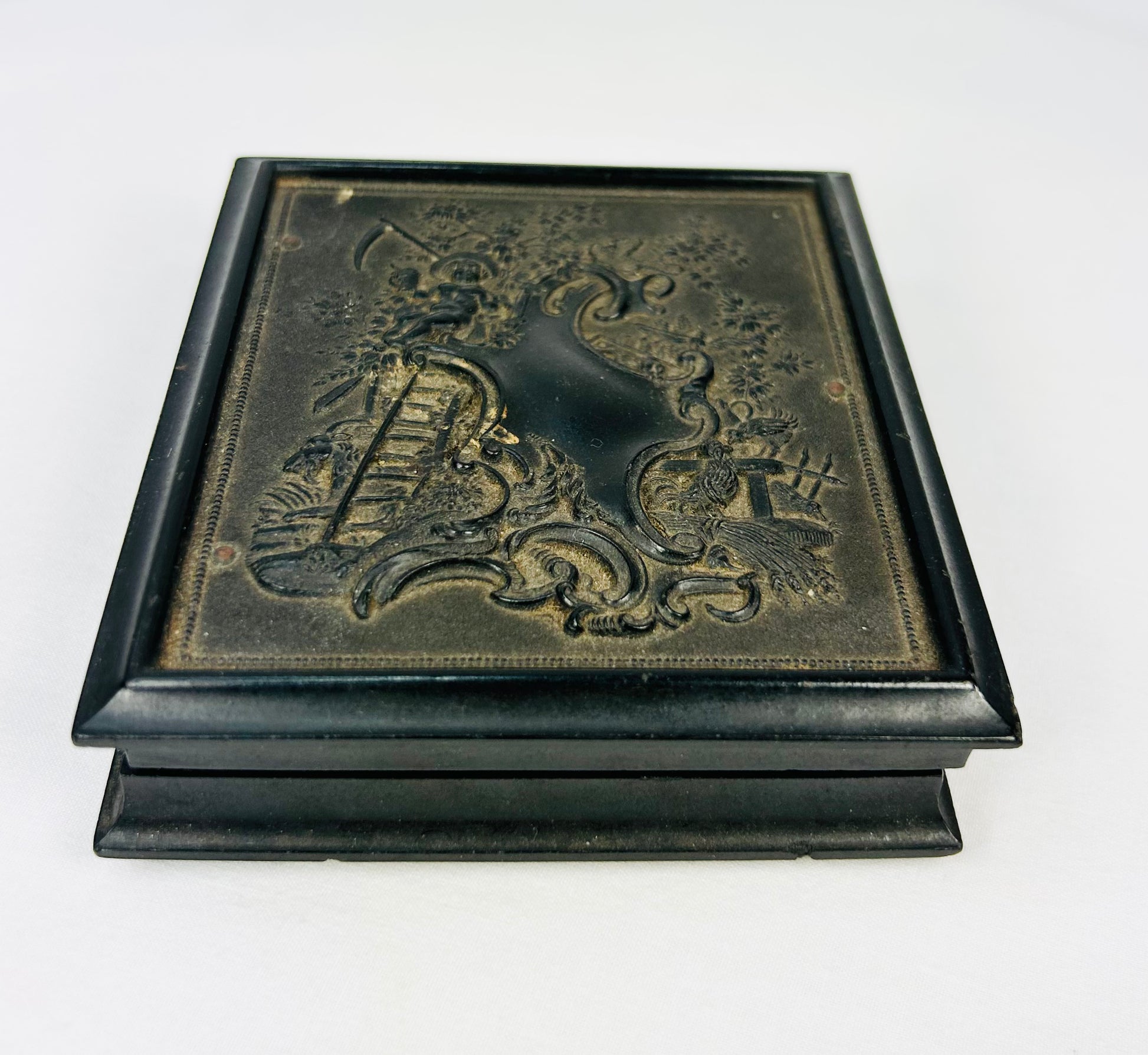 Closed Victorian daguerreotype case with embossed floral and scrollwork design