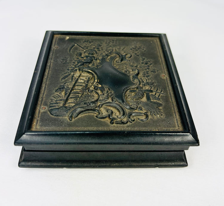 Closed Victorian daguerreotype case with embossed floral and scrollwork design