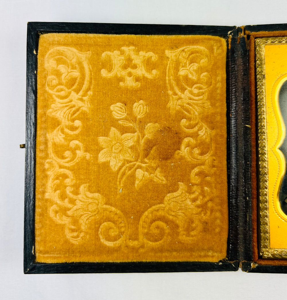 Victorian yellow velvet case lining with embossed floral scrollwork, ambrotype interior