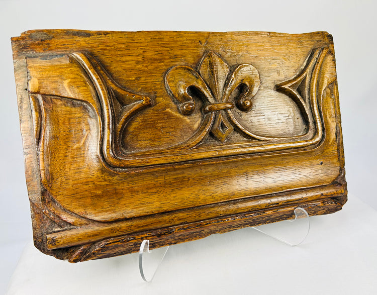 Angled view of antique Gothic oak relief panel showing carved fleur-de-lis design