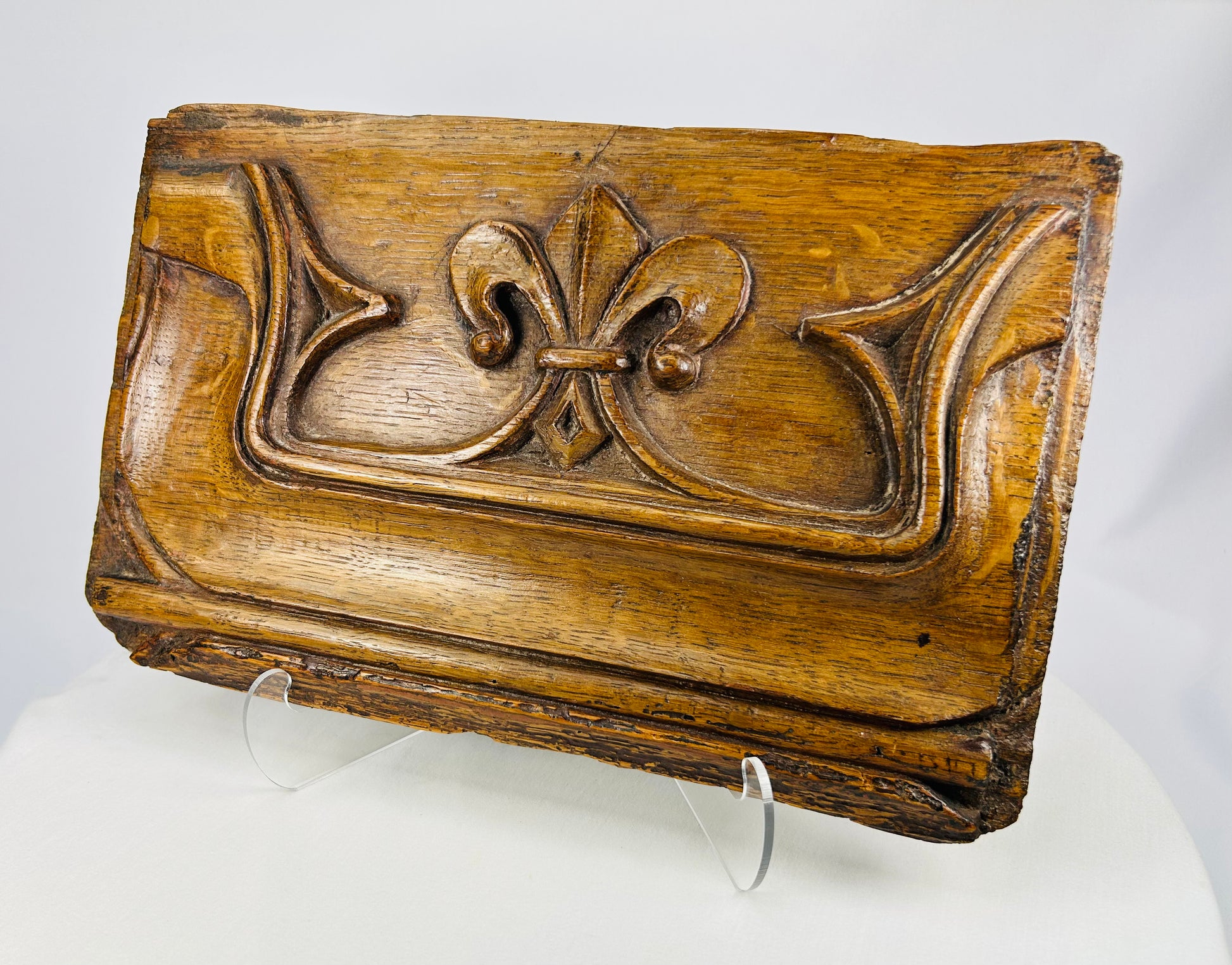 Historic carved oak panel from the 1500s with detailed fleur-de-lis relief