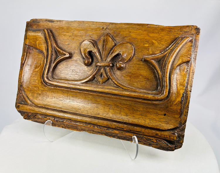Historic carved oak panel from the 1500s with detailed fleur-de-lis relief