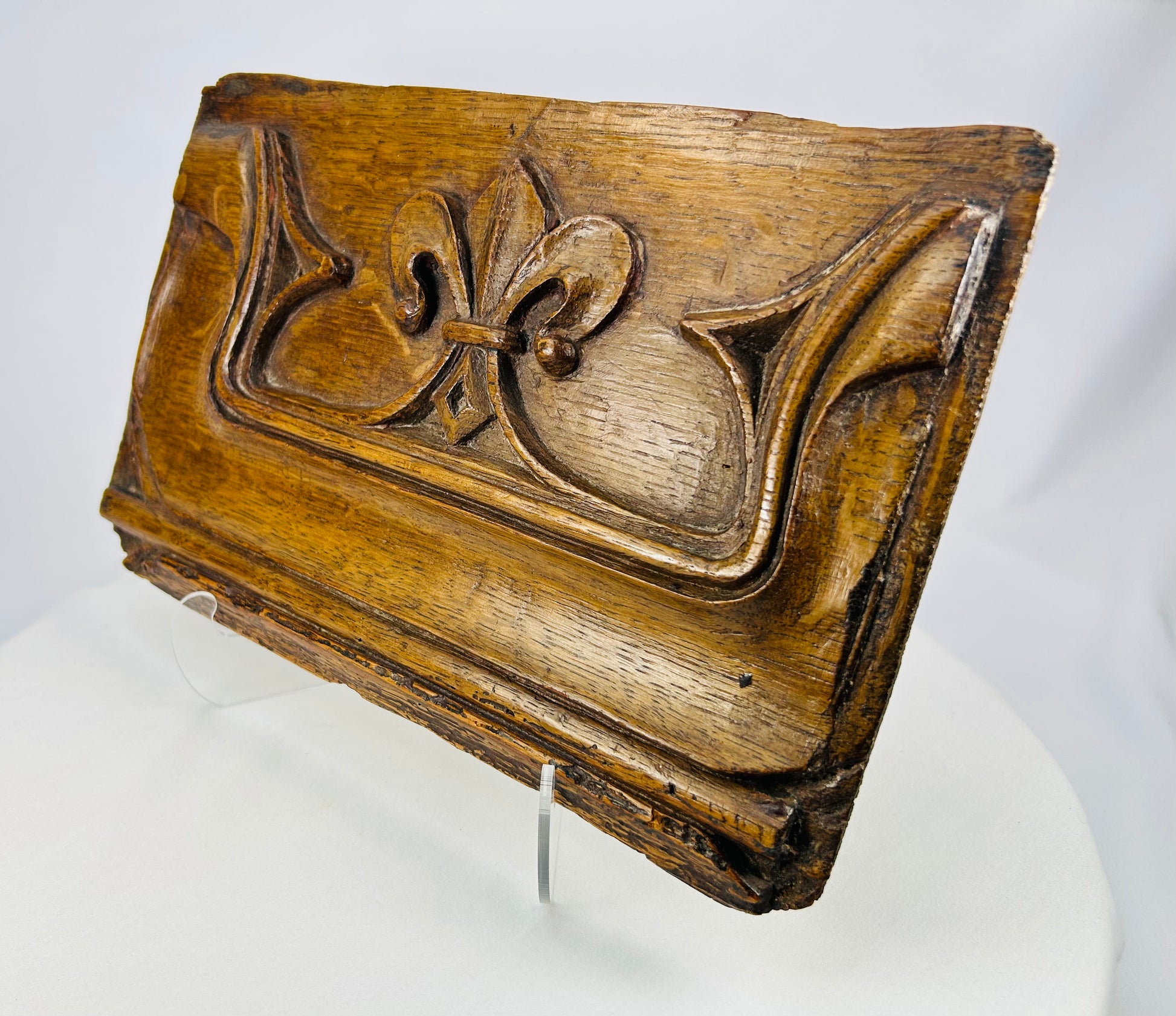 Angled photograph of antique oak panel with Gothic flourishes