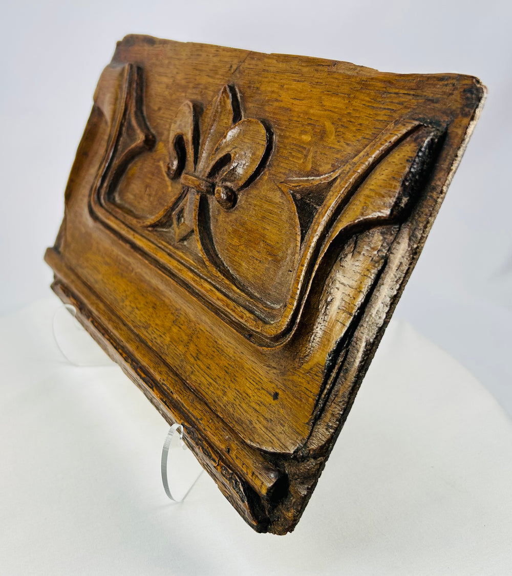 Antique wooden panel photographed from an angle to show carved contours