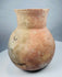 Restored ancient pottery vessel with visible repair lines around the lower body