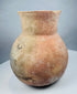 Restored ancient pottery vessel with visible repair lines around the lower body