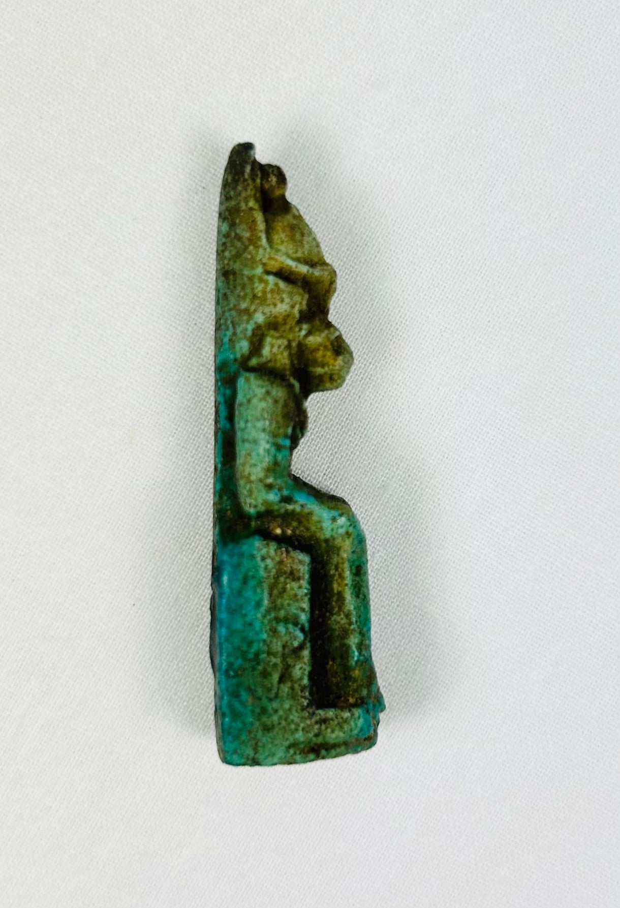 Detailed shot of ancient Sekhmet amulet showing facial carving and body posture.