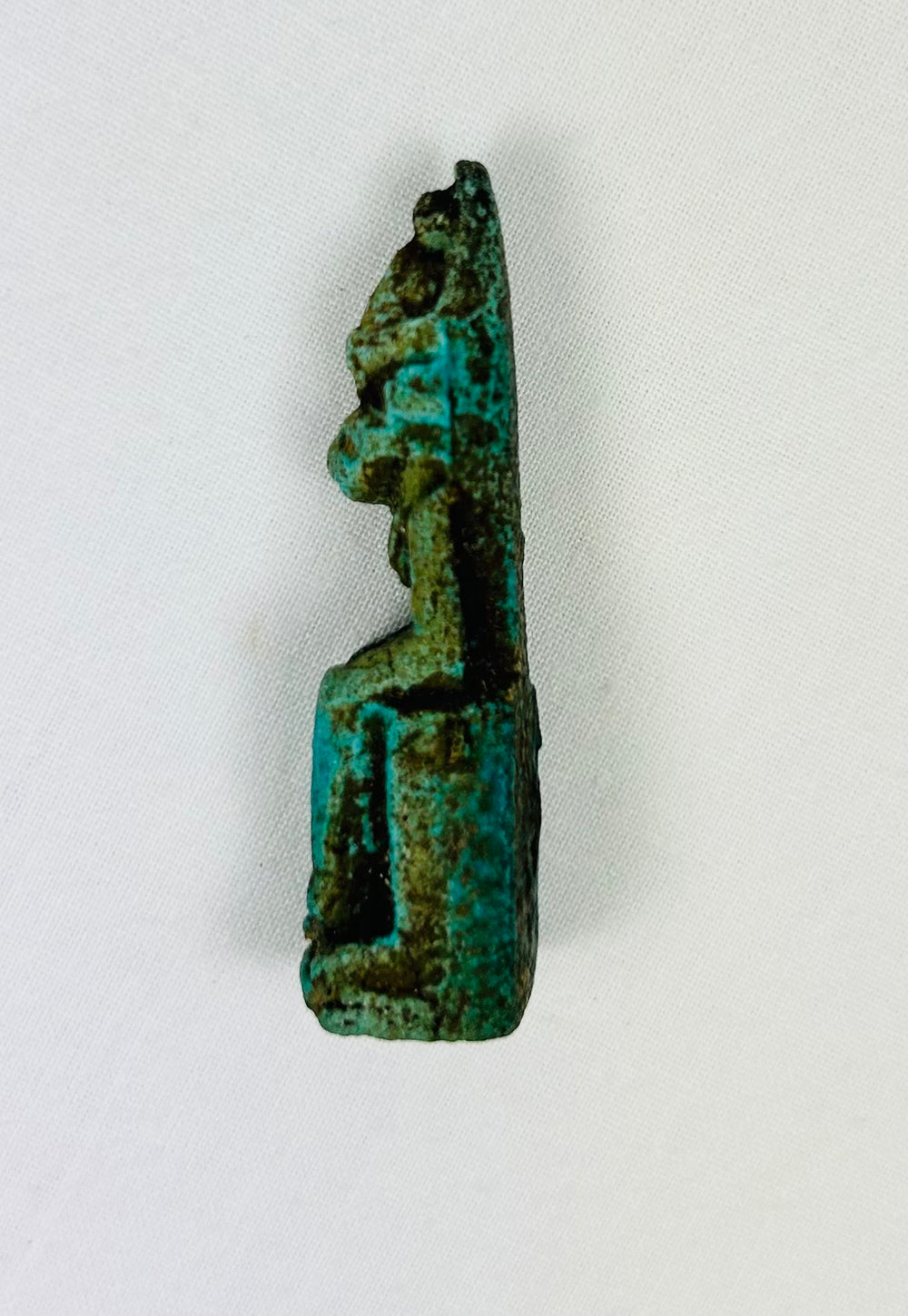 Ancient Egyptian protective deity sculpture in seated position, miniature amulet.