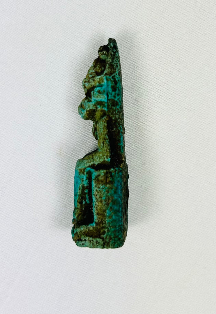 Ancient Egyptian protective deity sculpture in seated position, miniature amulet.