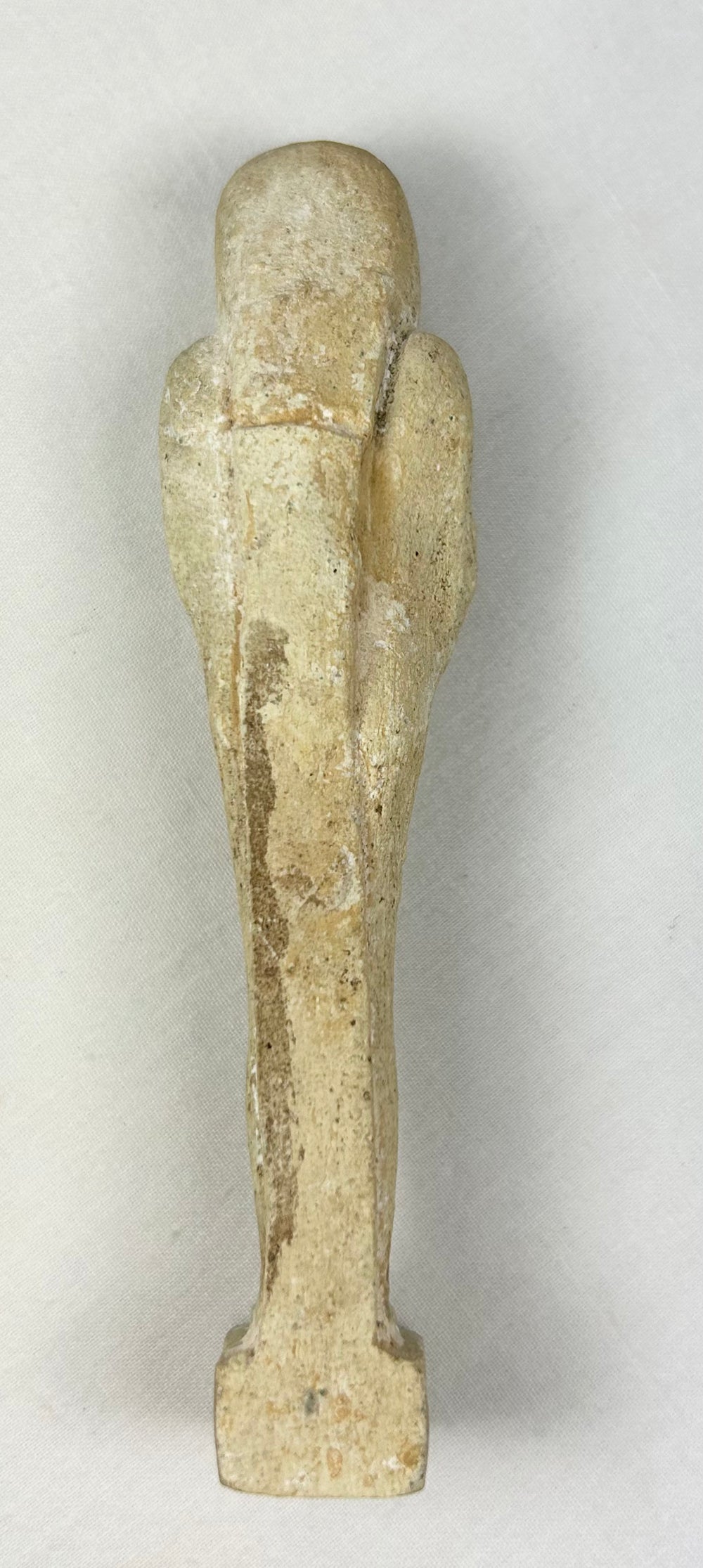 Rear view of a Late Period limestone ushabti against a neutral background
