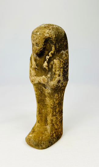 Front view of an Egyptian ushabti with mineral surface deposits.