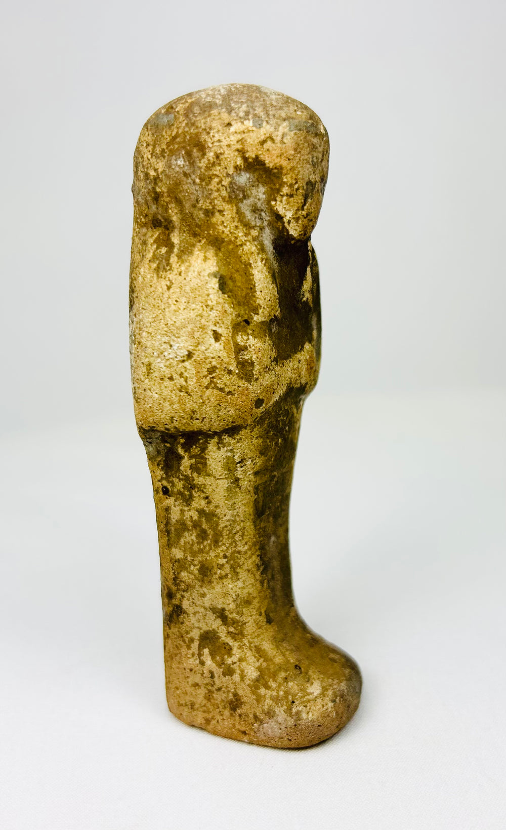 Tall slender Egyptian ushabti statue with aged ochre coloration.