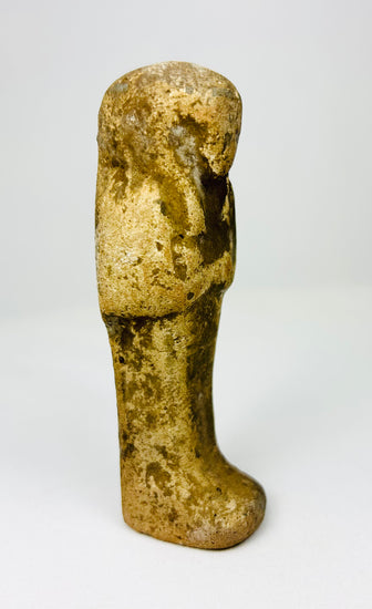 Tall slender Egyptian ushabti statue with aged ochre coloration.