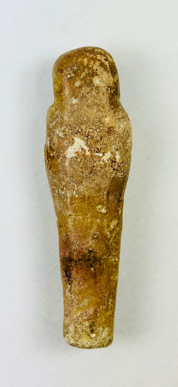 Rear view of a limestone ushabti showing natural aging and burial wear