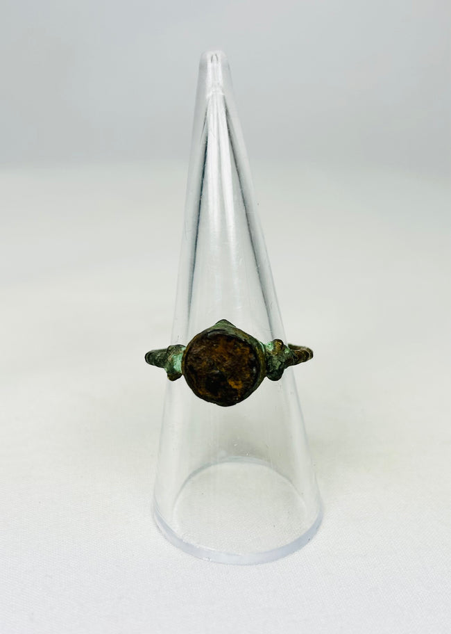 Corroded bronze ring from antiquity shown against a white background