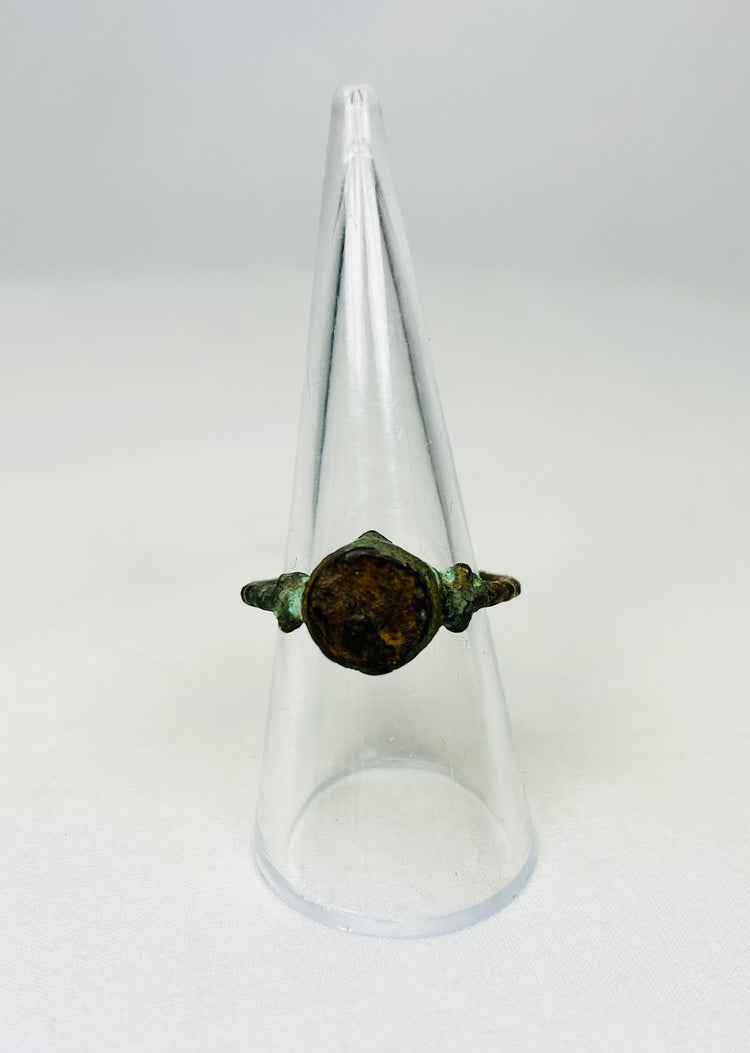 Corroded bronze ring from antiquity shown against a white background